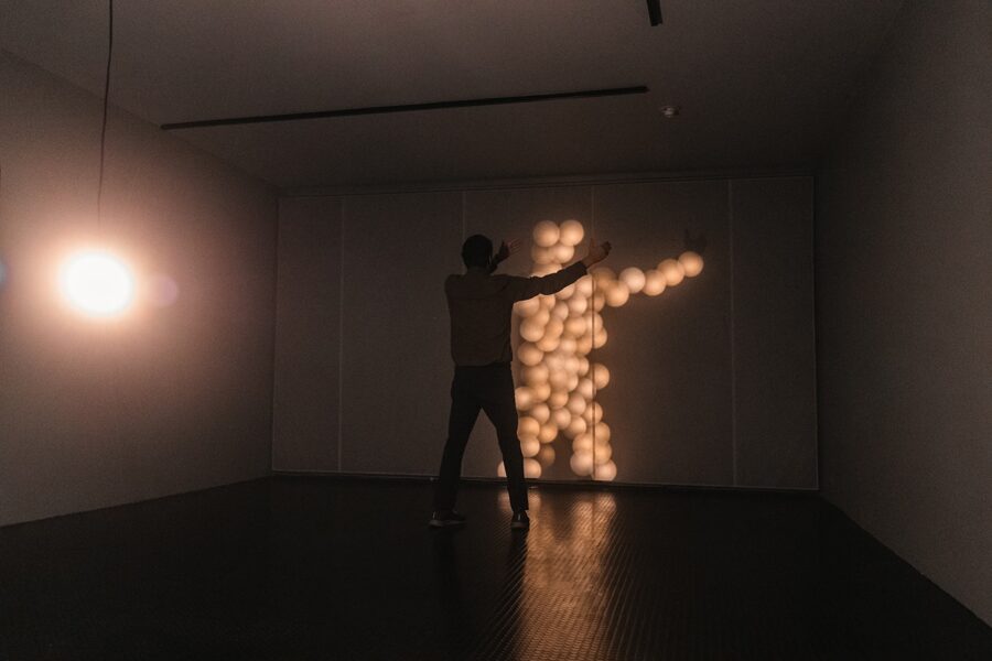 A person interacting with Brandon Lattu's Reciprocity of Light artwork.